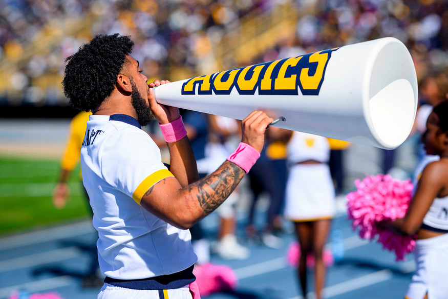 male cheerleader with an AGGIES megaphone