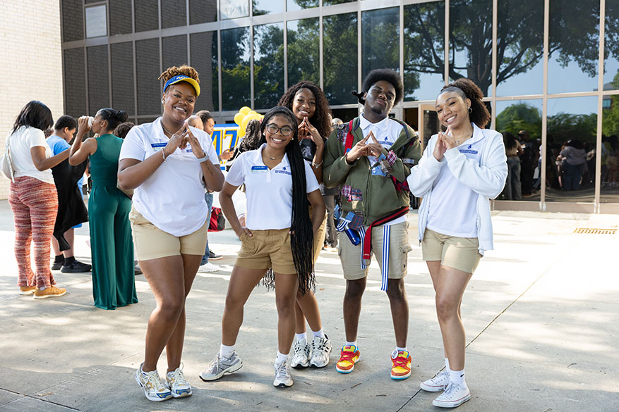 student ambassadors making the aggie hand sign